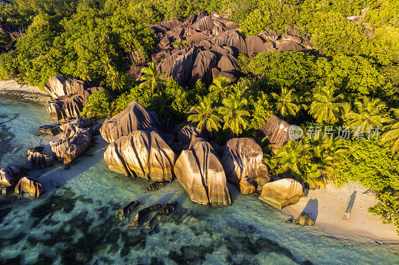 Anse Source d'Argent，塞舌尔，一对年轻的男女在热带海滩上